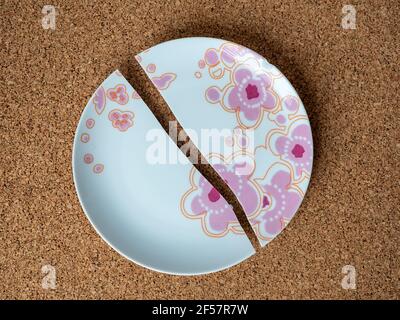 cracked plate on the background of a cork table Stock Photo