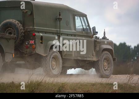army land rover defender speeding along a dusty stone track on salisbury plain wiltshire Stock Photo