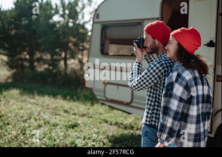 Romantic couple with a camera in nature near the trailer at home. Stock Photo