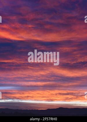 Epic scene of a cloudy sky during sunrise with purple and pink colors Stock Photo