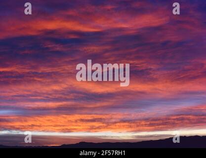 Epic scene of a cloudy sky during sunrise with purple and pink colors Stock Photo