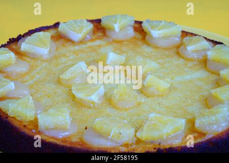 A round boiled Meyer lemon, almond and olive oil cake with sliced lemons on top Stock Photo