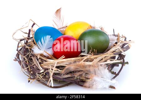 Colorful traditional painted Easter eggs in a nest on white background Stock Photo