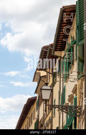 Neon Hotel Sign Viewed From Behind in Daylight, Florence Italy Stock Photo