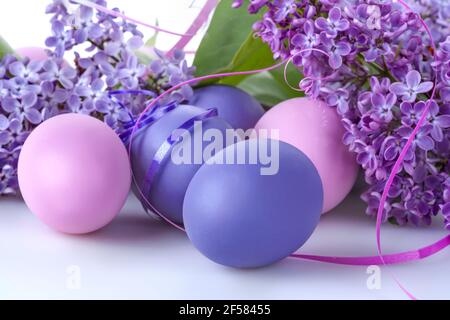 Colorfully Easter eggs with lilac flowers on a white background Stock Photo