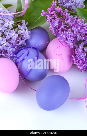 Colorfully Easter eggs with lilac flowers on a white background Stock Photo