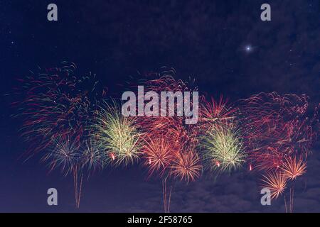 Beautiful colorful real fireworks with background blue sky cloudy and stars, celebration, festival. Stock Photo