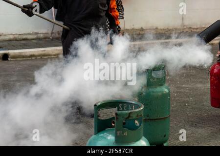 Man teaches how to use carbon dioxide  (CO2) fire extinguishers to extinguish fires from LPG cooking gas tanks. Stock Photo