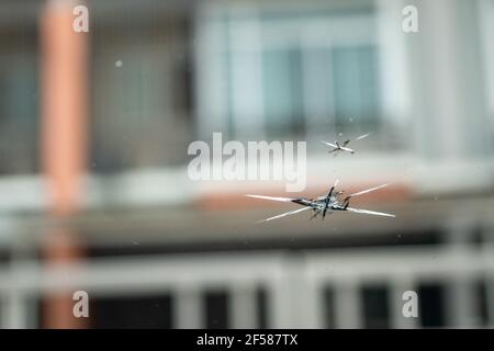 Windshield has cracks from the impact of stone chips while driving. Stock Photo