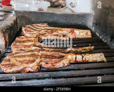 Tomahawk rib beef steak on hot black grill with flames Stock Photo