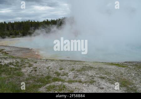 Late Spring in Yellowstone National Park: Steam from Grand Prismatic Spring Obscures Midway Bluff in the Excelsior Group of Midway Geyser Basin Stock Photo