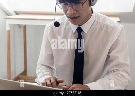 young confident male call center operator customer service representative doing his job on the phone with headset Stock Photo