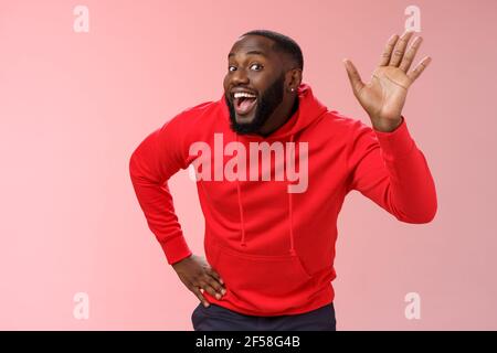 Attractive funny african american gay beard in red hoodie raise palm waving  hello hi howdy gesture acting feminine cute fool around welcoming guests  Stock Photo - Alamy