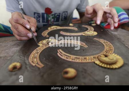 Workers make and sorting out copper and silver jewellery at Bhakurta village in Savar on the outskirts of Dhaka, Bangladesh, March 21, 2021. Thousands of pieces of flashy jewellery found at shops in the capital Dhaka are crafted in this village. Most people these days know the place as 'gohona gram' (jewellery village). Even though the jewellers say they have been living there for a few generations - nearly a century âÂ€Â“ it became well-known as gohona gram only two to three decades back. Making jewelleries is like a household chore in this village. Not just men, women and children also work Stock Photo