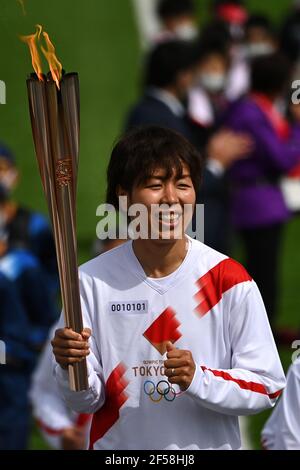 FUKUSHIMA, March 25, 2021  Iwashimizu Azusa, former member of 'Nadeshiko Japan', the Japan women's National Football Team, runs as one of torchbearers on the first day of the Tokyo 2020 Olympic torch relay in Futaba, Fukushima of Japan, on March 25, 2021. (Philip Fong/POOL via Xinhua) Stock Photo