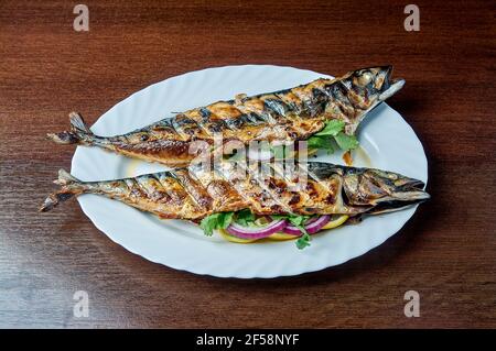 Mackerel baked on the grill lies on a white plate Stock Photo