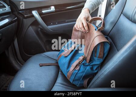 The action of stealing bag from passenger seat of a car, male arm reach out for a handbag through the opened door Stock Photo