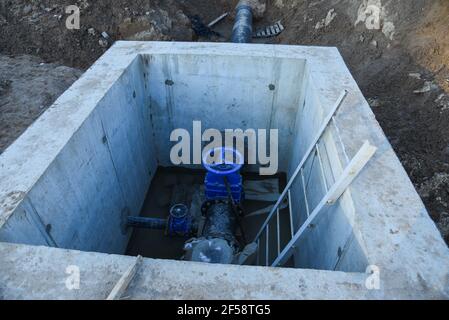 Resilient Seated Gate Valves connect pipeline of water supply in concrete bunker at constructin site. Solutions for drinking water and sewage. Valve p Stock Photo