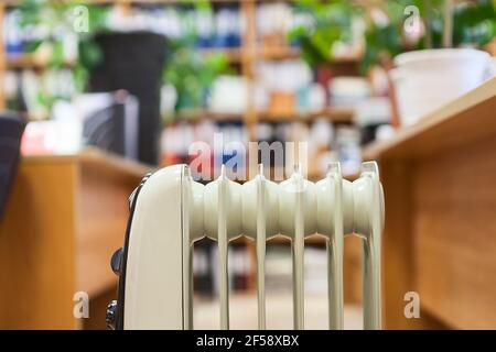 Heating surface of oil heater is on foreground and office space is on a background Stock Photo