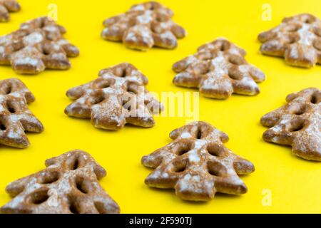Christmas tree cookies on wooden background. New Year's food. Festive baked goods. Gingerbread on the table. Icing sugar sweetness taste season. Pattern. Stock Photo