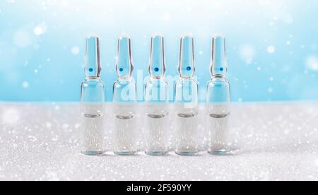 Medical ampoules for injection on a white background. Glass ampoules with medicine on the table. Medicines and disease treatment, pharmacology and sci Stock Photo