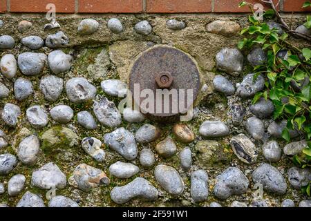 Detail of a flint wall with brick top, and an anchor plate Stock Photo