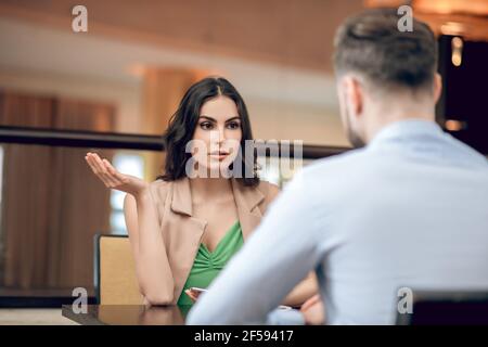 Young woman talking to a man and looking disappointed Stock Photo