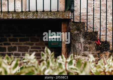 Green post box on stone wall under stairs. High quality photo Stock Photo