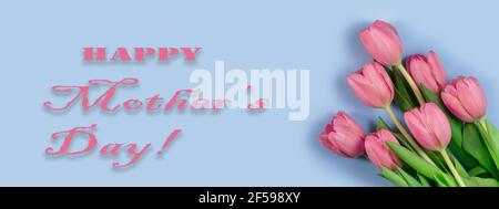 Pink tulips flowers on blue background. Card for Mothers day, 8 March. Floral composition with beautiful fresh tulips. Mothers day card. Flat lay, top Stock Photo