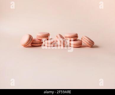 Monochrome macaroni or macaroons on a pink background. French almond cookies with filling. Copy space. Front view. Stock Photo