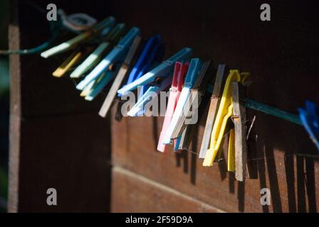 Colorful, old clothespins on wooden wall Stock Photo