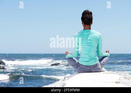 Portrait from behind of yoga woman at the beach Stock Photo
