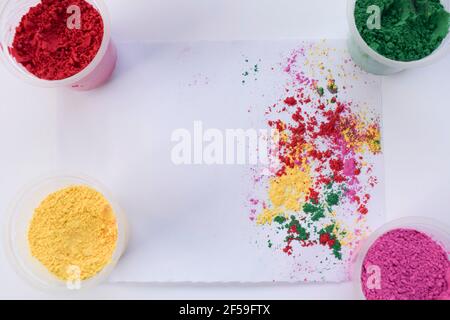 Holi colours powder scattered on white background with colours scattered splash Top view of holi colors for Indian festival of colour. Background wall Stock Photo