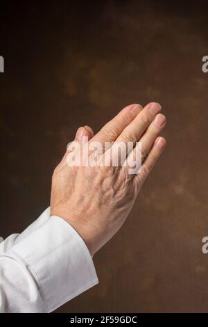 Man's hands in praying position Stock Photo