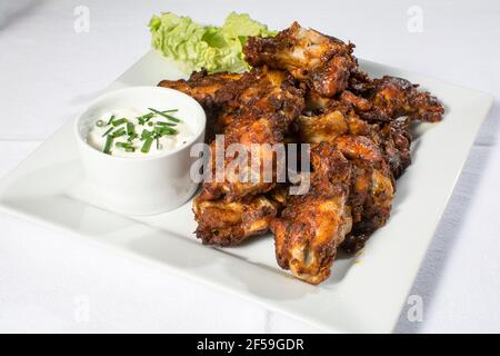 A plate of spicy BBQ chicken wings with dip Stock Photo