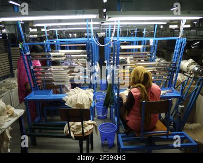 Workers of garment sector on a knitting machine in Bangladesh inside a factory in Dhaka Stock Photo