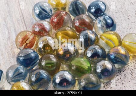 Red, yellow, green and blue glass marbles on a wooden surface Stock Photo
