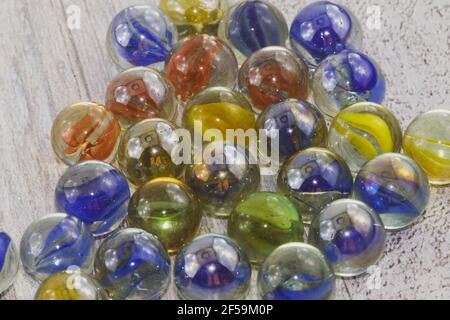 Red, yellow, green and blue glass marbles on a wooden surface Stock Photo