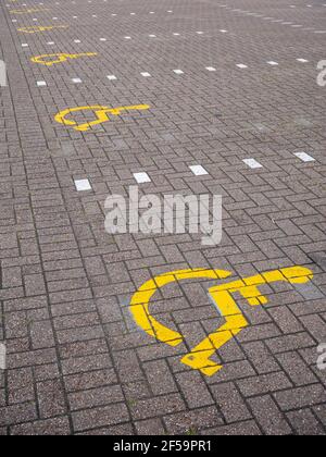 Disabled parking bay signs painted on the floor of a carpark at a shopping centre in the United Kingdom. Stock Photo