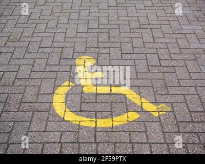 A disabled parking bay sign painted on the floor of a carpark at a shopping centre in the United Kingdom. Stock Photo