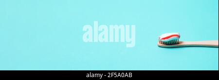 Closeup of a new toothbrush and toothpaste on blue background with copy space. Stock Photo