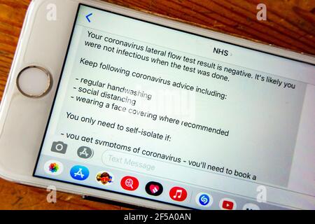 Mobile phone displaying the negative results of a coronavirus lateral flow test sent from the NHS during the third UK lockdown of the pandemic in 2021 Stock Photo