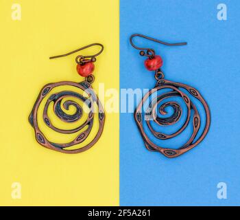 Ethnic decorations on colored sheets of paper. Earrings Rings Amulets Beads. Round Metal Earrings Stock Photo