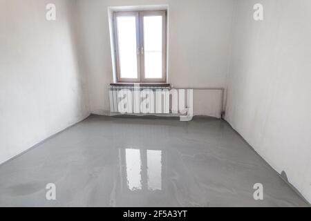 New self leveling floor is poured into the emty room. Stock Photo