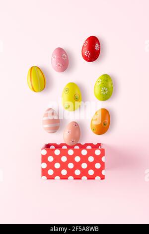 Gift box with Easter eggs on bright background. Minimal spring holiday concept. Stock Photo