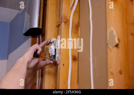 Preparing to remove an electrical outlet of the screws for electrical wires receptacle plug panel Stock Photo