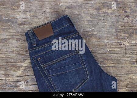 Fashion blue jeans on wooden background. Fashion clothing concept Stock Photo