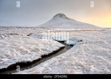 Brook near snowy mountain in countryside Stock Photo