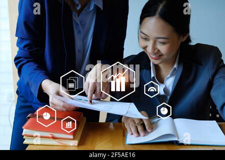 Fund managers team consultation and discuss about analysis Investment stock market by digital tablet with icon on virtual screen. Stock Photo