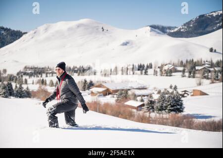 Man Walking through Deep Snowy Trail on Sunny Day in Ketchum, ID Stock Photo